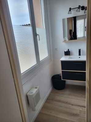 A bathroom with a large window, a white sink, a black cabinet, and a mirror. - Cosy bubble with private terrace and parking area Bed linen and towels provided (Tarbes)