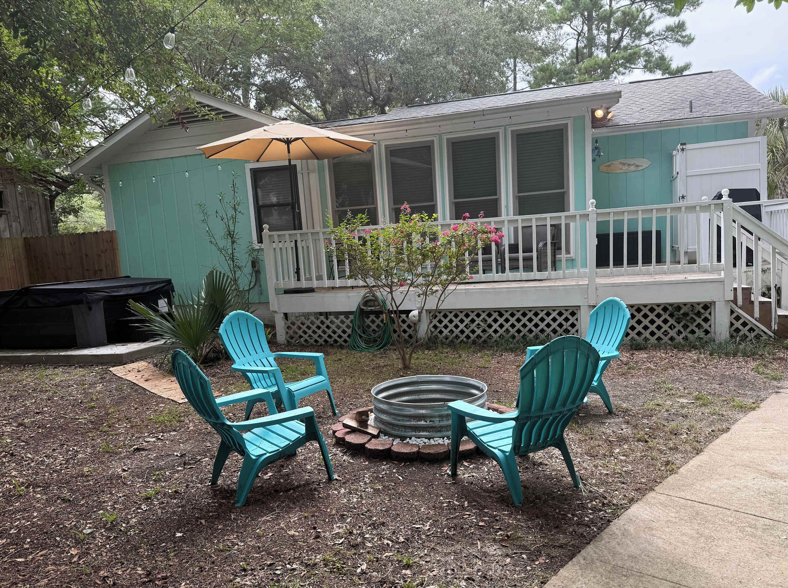 A house with a porch, outdoor seating, and a fire pit.