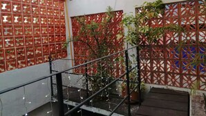 A staircase with a metal railing, surrounded by red and blue patterned walls with potted plants. - Apartments featuring Oaxaca art for 4 people (Oaxaca de Juárez)
