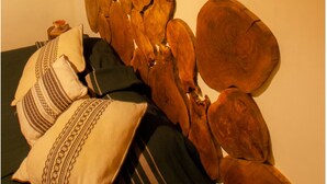 A bed with a wooden headboard, pillows, and a blanket. - Apartment featuring Oaxacan art for two people, with parking (Oaxaca de Juárez)