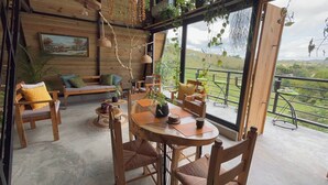A wooden interior with a dining area, seating, and a view of the outdoors.