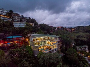A multi-story building with balconies, surrounded by dense greenery. - OUTSTANDING LUXURY, BREATHTAKING VIEWS, 150MB WIFI (Quepos)