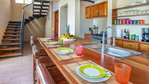 Una cocina moderna con una isla de madera, un lavaplatos de acero inoxidable y armarios de madera.