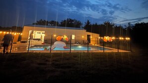 Edifici amb piscina, envoltat per una tanca amb llums de garlandes.