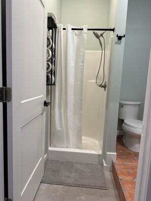 Regadera, toallas, papel de baño 