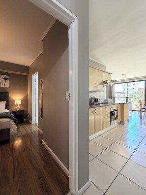 Un apartamento moderno con una habitación, kitchenette y vistas al exterior.