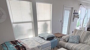 Une pièce comprenant un lit, un canapé, une table basse et une porte.