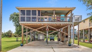 Un bâtiment à deux étages doté d’un balcon, d’un porche couvert et d’un véhicule garé devant.