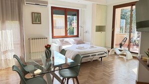 Une chambre à coucher avec un lit, une table de chevet, une lampe et une vue sur l’extérieur.