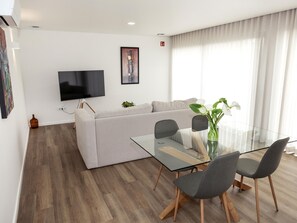 Ein modernes Wohnzimmer mit einer Couch, einem Glastisch und Stühlen.