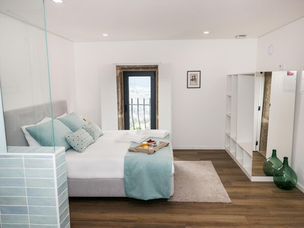 A modern bedroom with a bed, a breakfast tray, a view through the window, and a wardrobe. - Cerca da Milhera | Suite 1 Nazaré | Country House | Swimming Pool | Minho (Ponte da Barca)