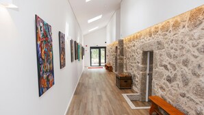 A hallway with wooden flooring, a stone wall, and a bench. - Cerca da Milhera | Suite 2 Corridinho | Country House | Swimming Pool | Minho (Ponte da Barca)