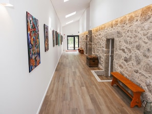 Ein Flur mit Holzboden, Steinwand und einer Bank.