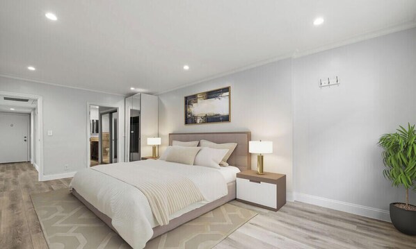 Un dormitorio moderno con una cama grande, mesitas de noche, una lámpara de noche, una planta en maceta y un cuadro en la pared.