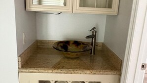 Un baño con lavamanos, espejo y armario de diseño calado.