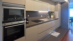 Eine moderne Küche mit Einbaugeräten, einer Arbeitsfläche und einem Essbereich mit Blick.
