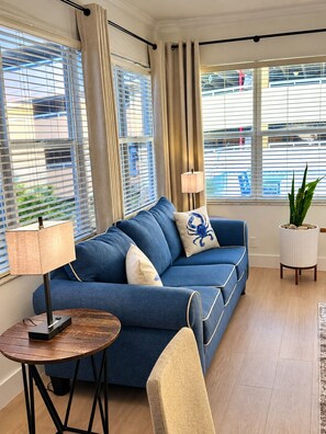 A modern living room with a blue sofa, a small round table, and a potted plant. - Premium Oversized Vacation Condo! Steps to the Broadwalk & Beach.
Game Lounge. (Hollywood)