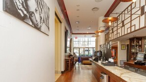 A hotel lobby with a marble reception desk, a large window, and a wall-mounted artwork. - NYC Stay Near Times Square, Broadway & Dining with King Guest Room Comfort (New York)