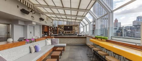 Una zona de bar moderna con asientos y una cocina al fondo.