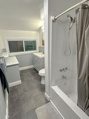 A modern bathroom with a shower, toilet, and sink. - Arcade, Close to Fall, 4bdrm,  off street Parking (Niagara Falls)