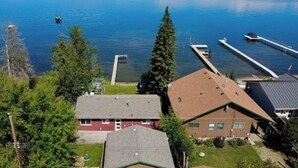 A residential area with houses, a dock, and boats on a lake.