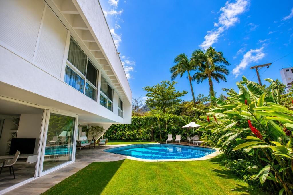 Una piscina al aire libre, sombrillas, sillones reclinables de piscina