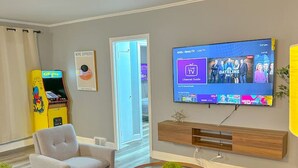 Un salon moderne comprenant un canapé, un fauteuil, une table basse et un téléviseur affichant un guide des chaînes.