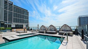 A rooftop pool with a clear view of the city skyline, surrounded by modern buildings and furnished seating areas. - Luxury 1BR+Den 2BA Rooftop Pool Miami (Miami)