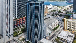 A high-rise building with a modern architectural design, surrounded by other high-rise buildings and a coastal cityscape. - Luxury 1BR+Den 2BA Rooftop Pool Miami (Miami)