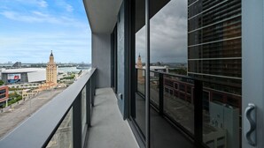 A balcony with a view of a cityscape, including a prominent tower and modern buildings. - Luxury 1BR+Den 2BA Rooftop Pool Miami (Miami)