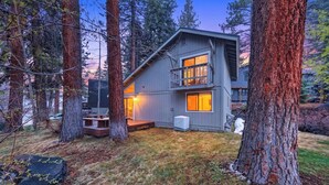 A modern cabin with a deck, surrounded by tall trees, and a clear view of the sky. - Incline Pines Retreat by Avantstay Private Hot Tub + Wraparound Deck + Views Near Dining and Shops (Incline Village)