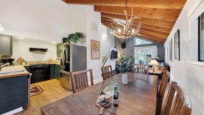 A spacious dining area with a wooden table, chairs, and a chandelier. - Incline Pines Retreat by Avantstay Private Hot Tub + Wraparound Deck + Views Near Dining and Shops (Incline Village)