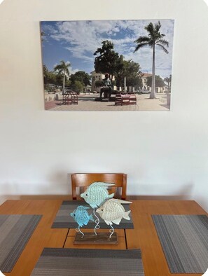 A dining table with a wooden chair and two fish-shaped sculptures.