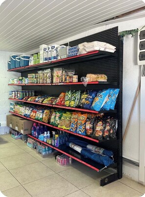 A storage rack with shelves holding various food items and household supplies.