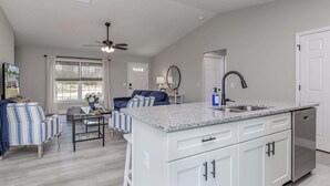 A modern kitchen with a large island, white cabinetry, and a ceiling fan. - ‼️Citrus Springs 3BR - Gulf & Springs 30 Min (Citrus Springs)