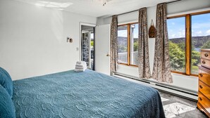 A bedroom with a bed, a ceiling fan, a window with curtains, and a view of the outdoors. - Terra Alta Lake View - Pool, Game Room (Terra Alta)