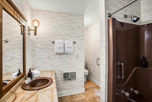 A bathroom with a marble sink, a shower with a glass door, and a toilet with a vent. - Terra Alta Lake View | Nearby Resort Pool & Games (Terra Alta)