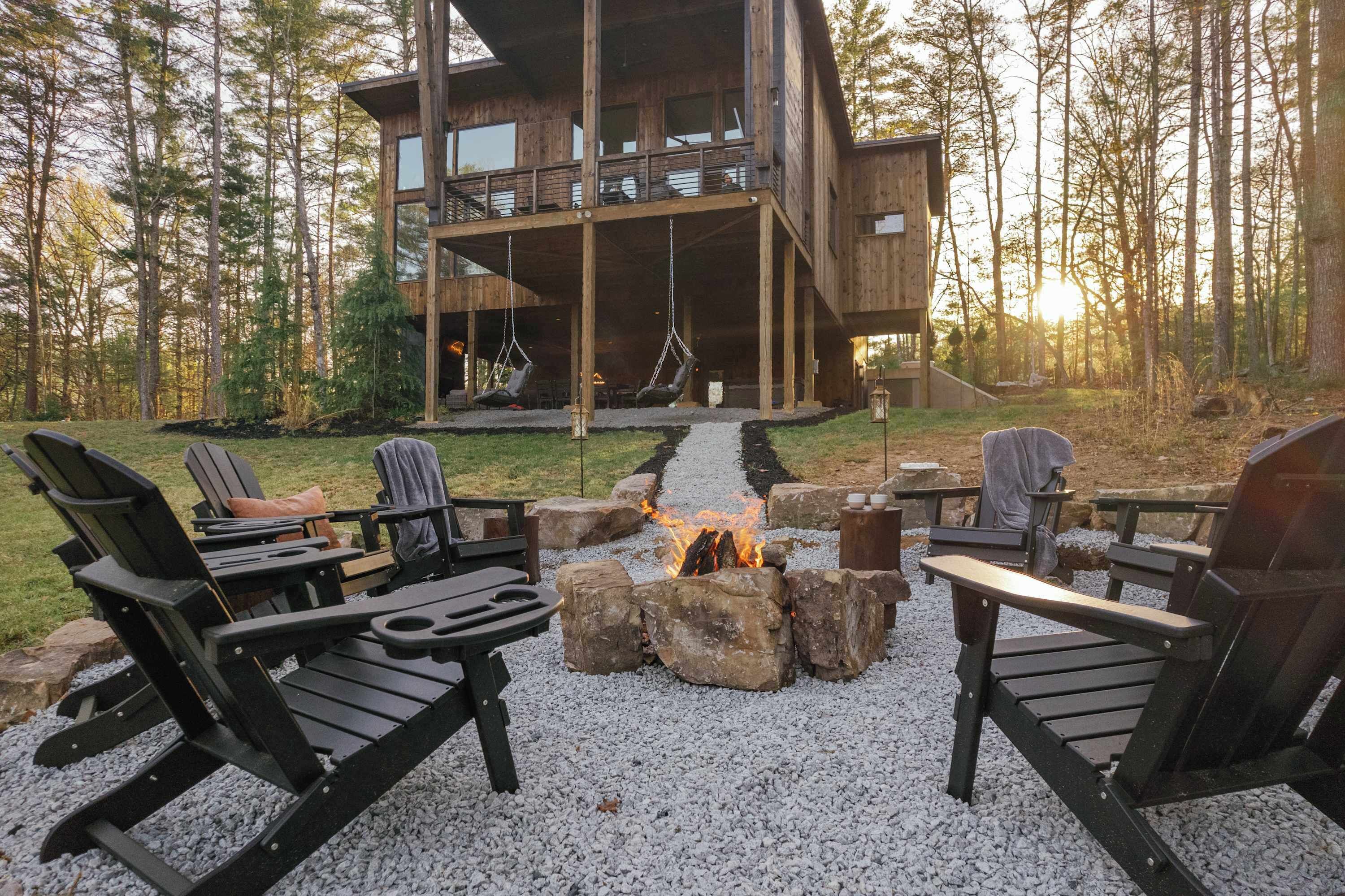 A wooden cabin with outdoor seating and a fire pit.