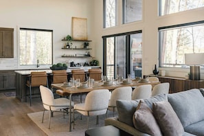 A modern kitchen with a dining area, large windows, and a view of the outdoors. - The Canopy House - Hot Tub, Sauna, Mountain View (Blue Ridge)