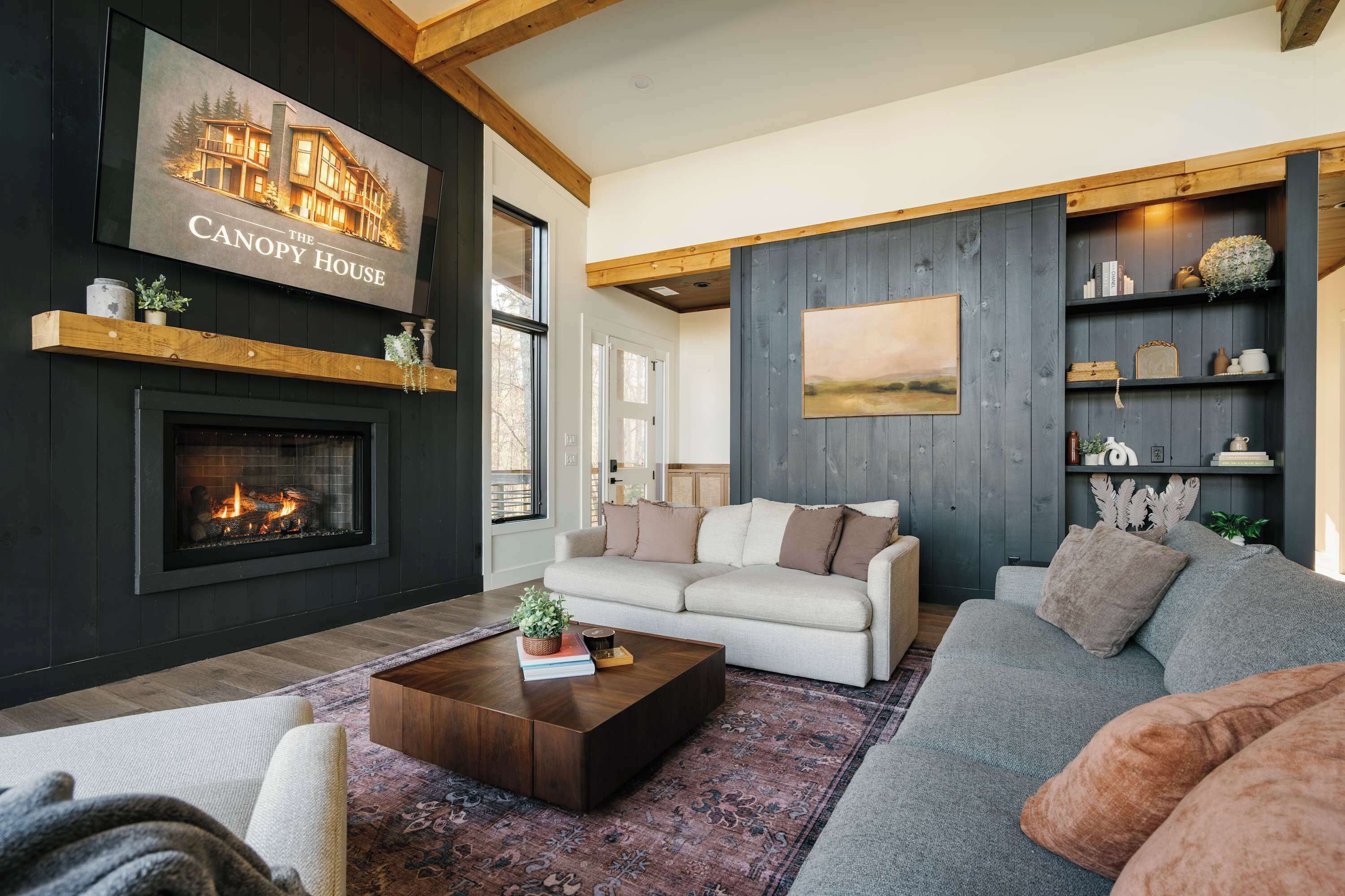 A living room with a fireplace, a sofa, a coffee table, and a bookshelf.