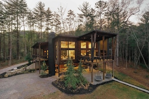 A cabin with a deck, surrounded by trees. - The Canopy House - Hot Tub, Sauna, Mountain View (Blue Ridge)