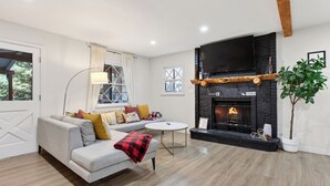 A living room with a fireplace, sofa, and a television.
