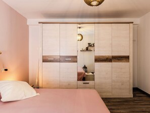 Ein Schlafzimmer mit einem Bett, einem Kleiderschrank und einem Nachttisch.