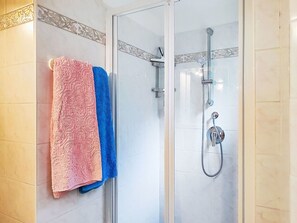 Eine Dusche mit Handbrause und am Wand montiertem Wasserhahn.