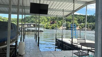 Un espace extérieur abrité, équipé d’un barbecue, de sièges et d’un écran de télévision.