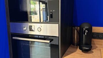 A modern kitchen with a built-in oven, a coffee maker, and a window with a view.