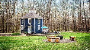 A blue house with a porch, surrounded by a forest. - Cozy 3BR Octagon Cabin-Near Ricketts Glen (Benton)
