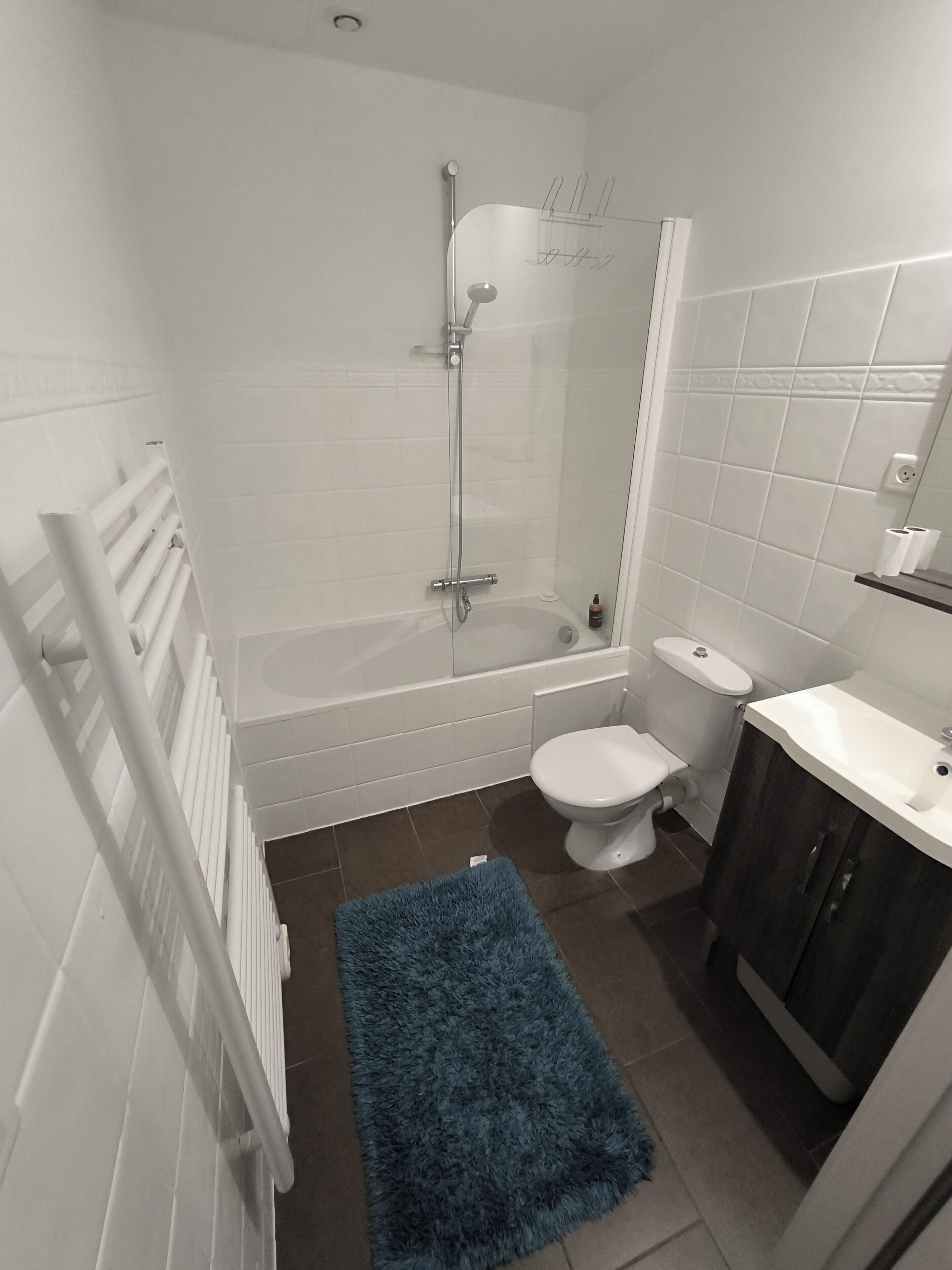 A bathroom with a shower, toilet, and sink.