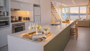 Una cucina moderna con isola centrale, elettrodomestici in acciaio inossidabile e vista sull'esterno.