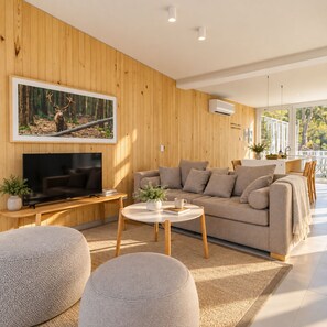 A modern living room with a flat-screen TV, a beige sofa, and a coffee table. - Signature Lake View Luxury Residences Unit H25 (BARILOCHE - SAN CARLOS DE BARILOCHE)